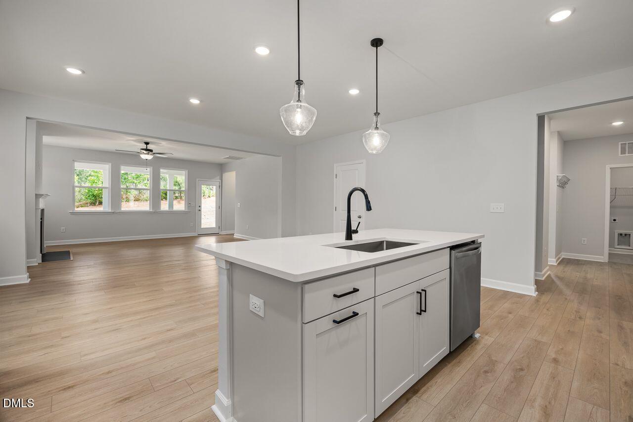 Modern kitchen island with pendant lighting and open-concept living area in The Birch II A home, Montrose, Aberdeen, NC.