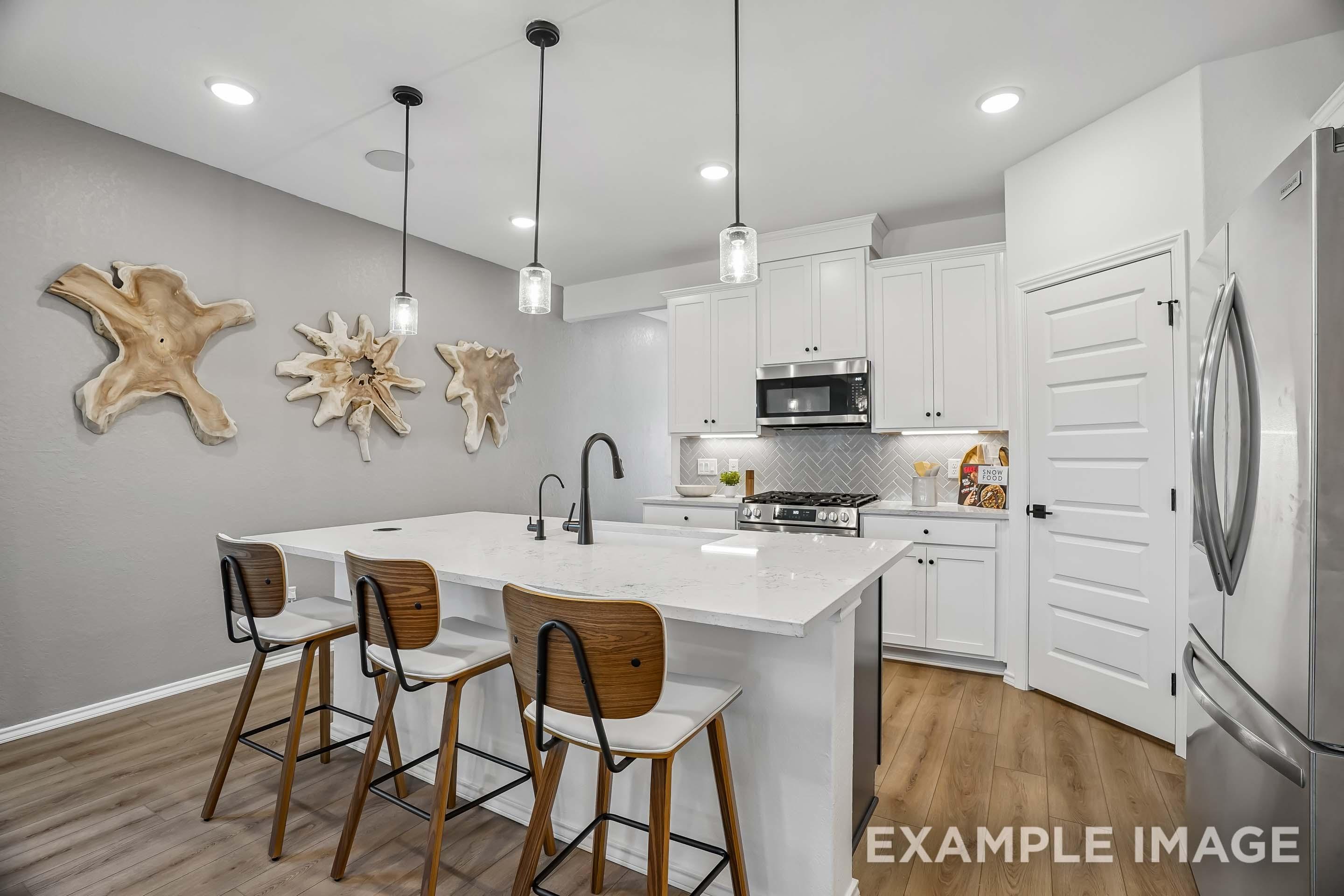 Modern kitchen in The Pinecrest D design featuring white cabinetry, quartz island, and stylish wood wall decor.