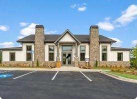 Modern stone-accented clubhouse with large glass entrance and parking lot in Hemingway, Cumming, Georgia by Davidson Homes