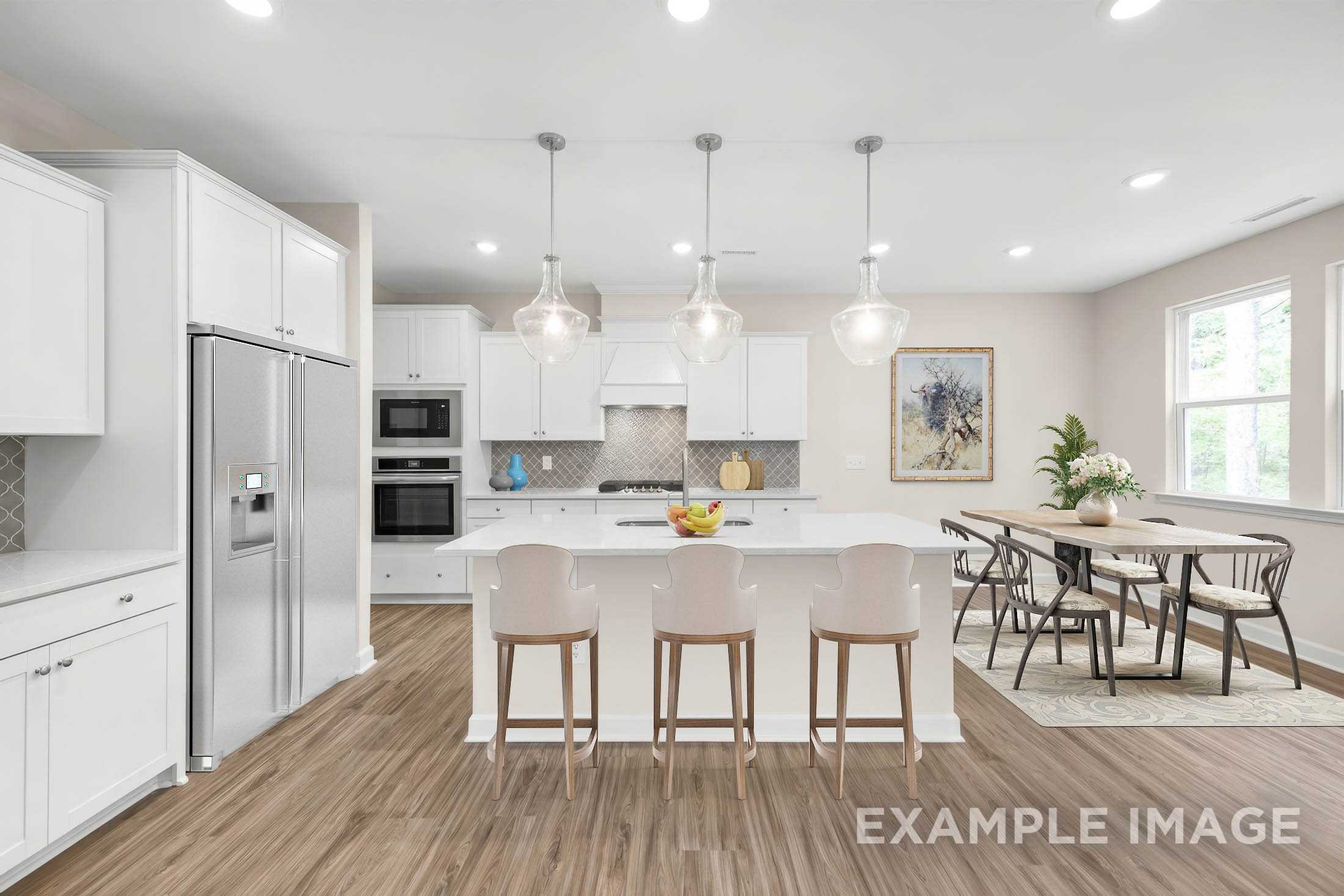 Spacious kitchen in The Gavin C with white shaker cabinets, stainless appliances, large island, and adjacent dining area