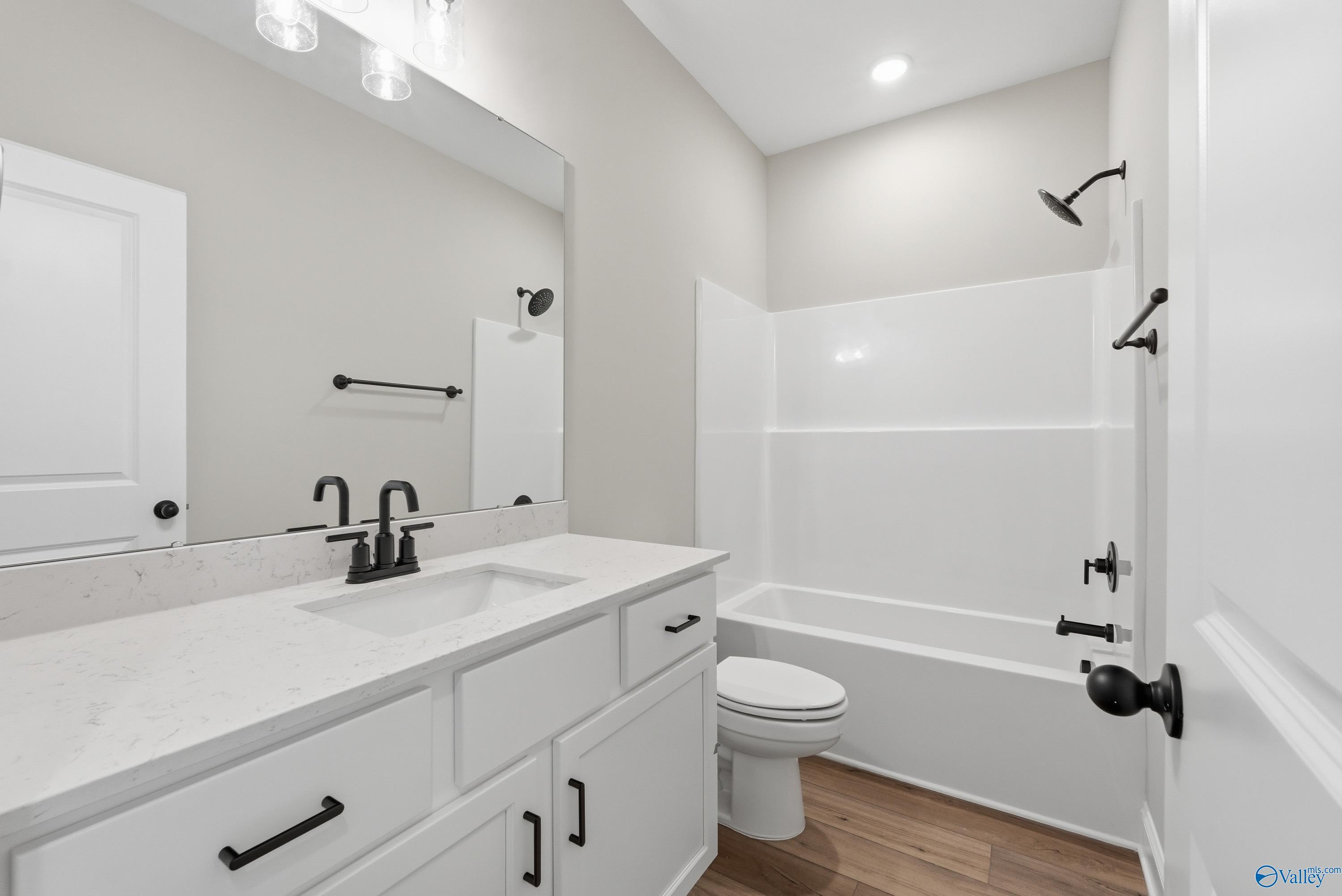 Modern bathroom with white quartz vanity, single sink, freestanding tub, walk-in shower in Davidson Homes The Laurel K, Cullman, AL
