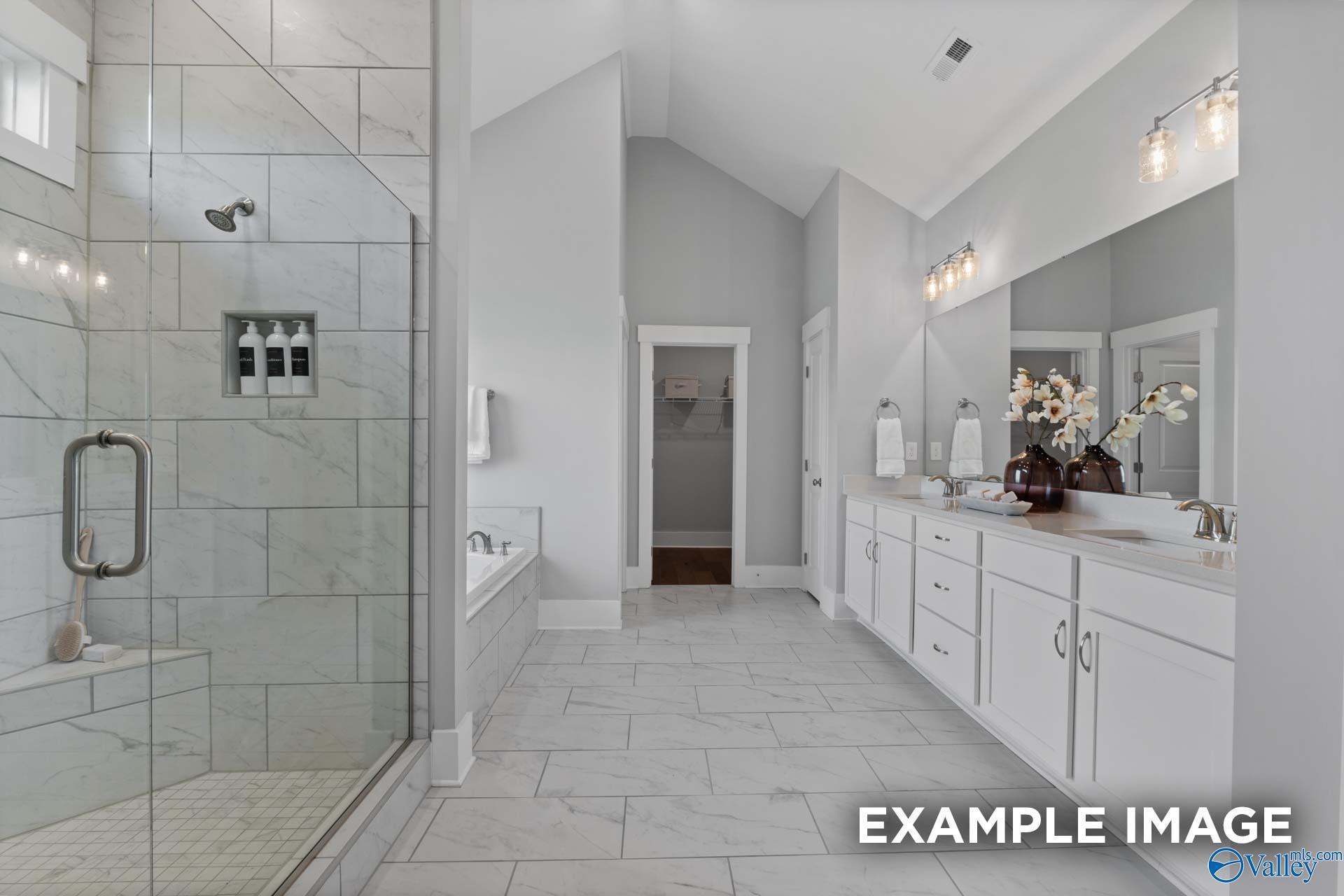 Elegant master bathroom with frameless glass shower, freestanding tub, and double vanity in Davidson Homes The Finleigh, Huntsville