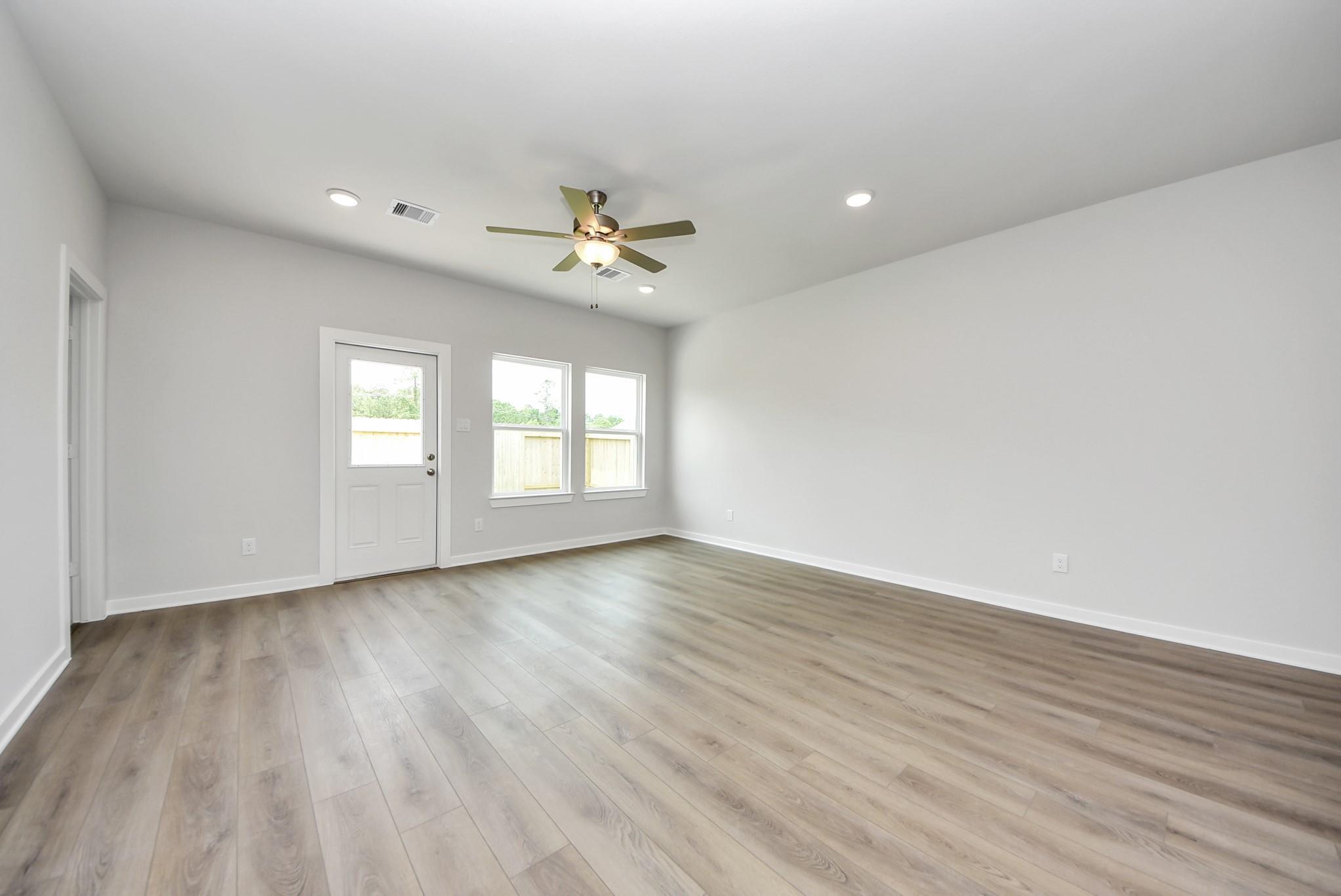 Bright, spacious living area with wood-look flooring and ceiling fan in The Blanco E floor plan, The Villages at WestPointe.