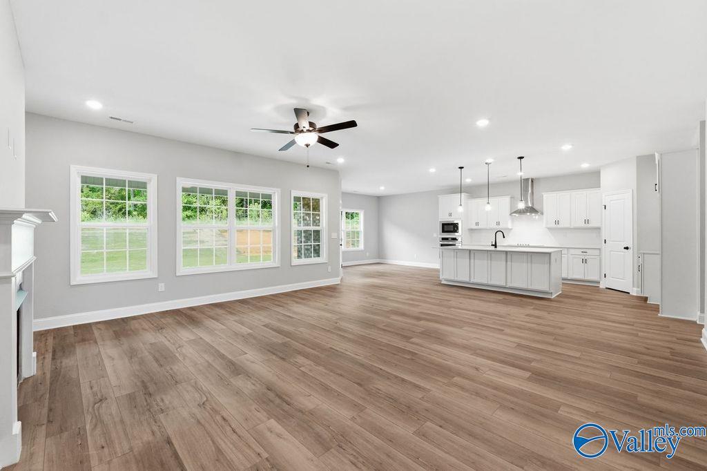 Open-concept living room and kitchen with white cabinetry in The Rockford floor plan at Cain Park, Hartselle, Alabama.