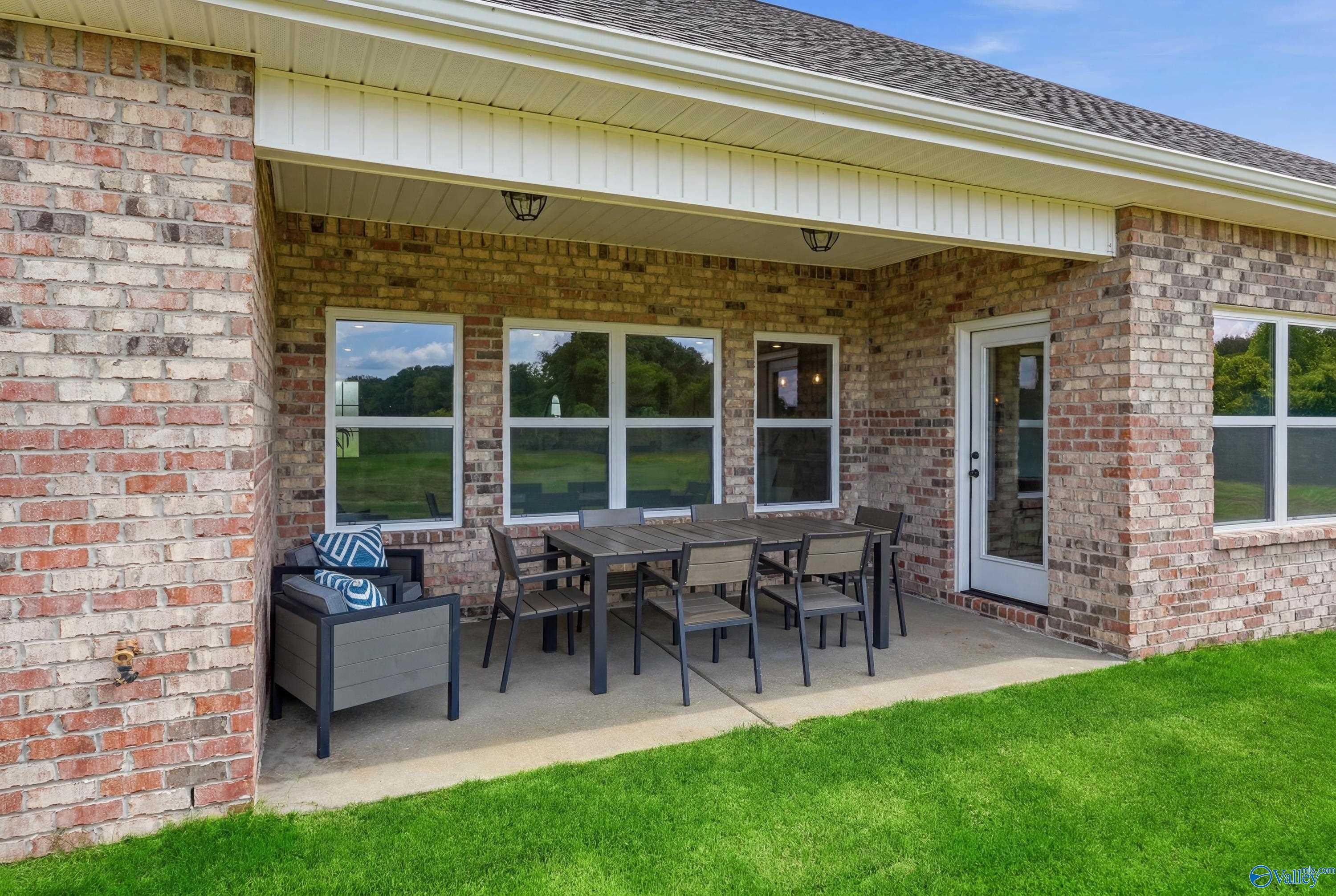 Covered brick patio with outdoor dining furniture at The Finleigh by Davidson Homes in Riverton Preserve, Huntsville.