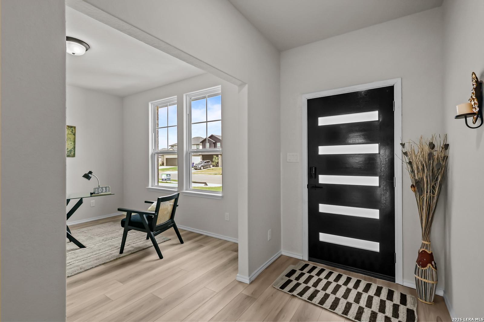 Modern home office with glass desk and black door in The Douglas C floor plan at Hannah Heights, Seguin, Texas.