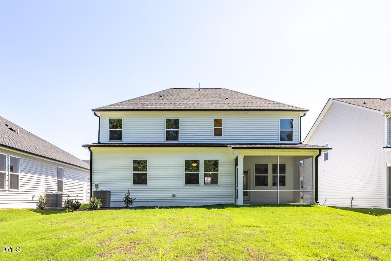 Two-story white home exterior with screened porch and spacious backyard in Woodland Crossing, Davidson Homes, Zebulon NC