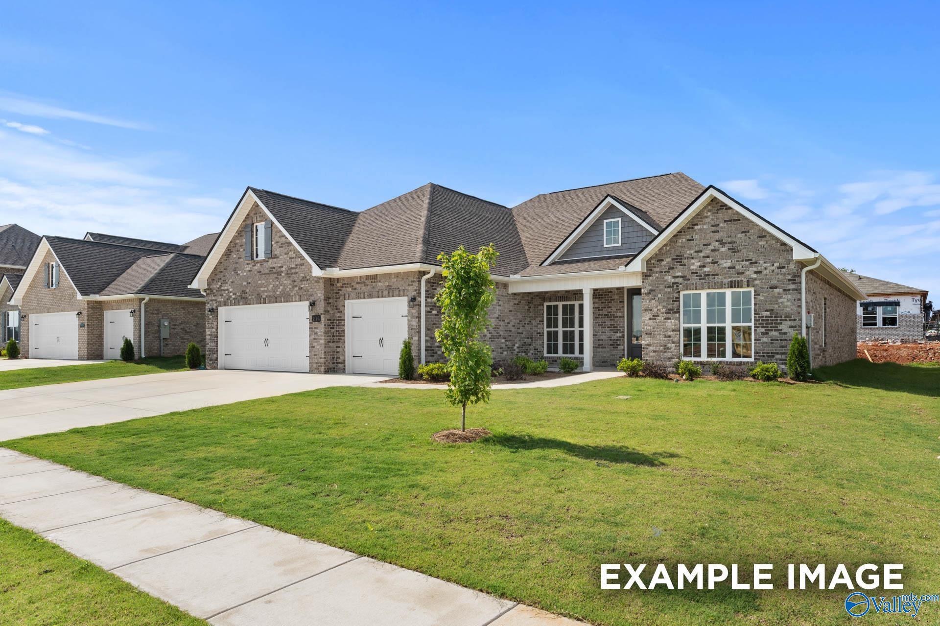Modern brick ranch home with 3-car garage, driveway, and landscaped front yard in Riverton Preserve, Huntsville, Alabama