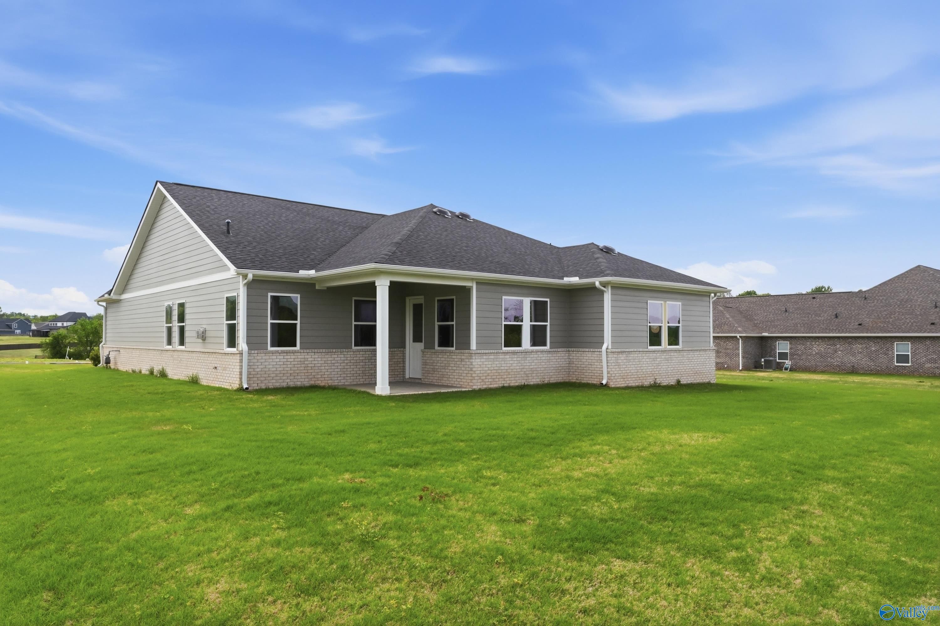 Gray-sided single-story Arcadia B home with covered porch, brick accents, and lush green lawn in Riverton Preserve, Huntsville AL