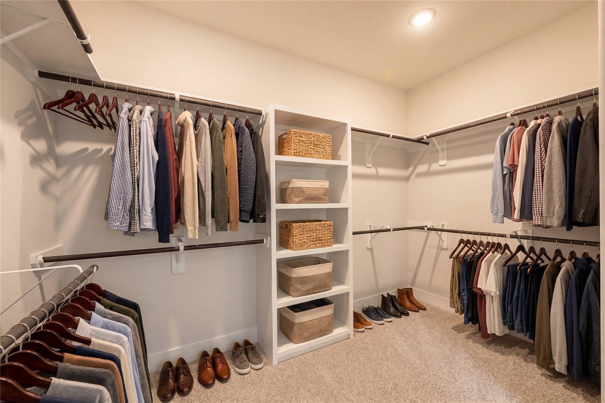 Spacious walk-in closet with hanging clothes, shelved baskets, and shoe storage in Davidson Homes The Philip A, Lago Mar, Texas City