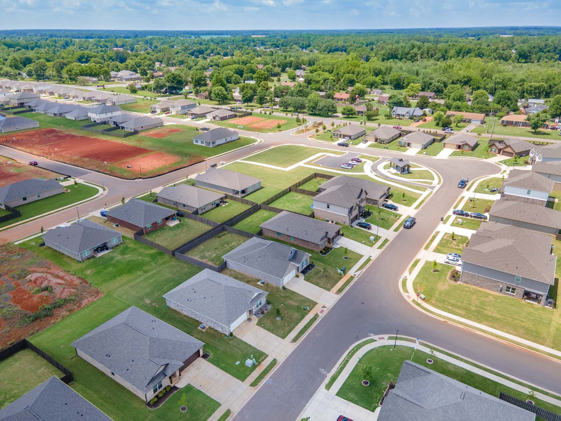 Aerial view of Clearview neighborhood in Hazel Green Alabama featuring new Davidson Homes, tree-lined streets, green lawns, and red clay tennis courts