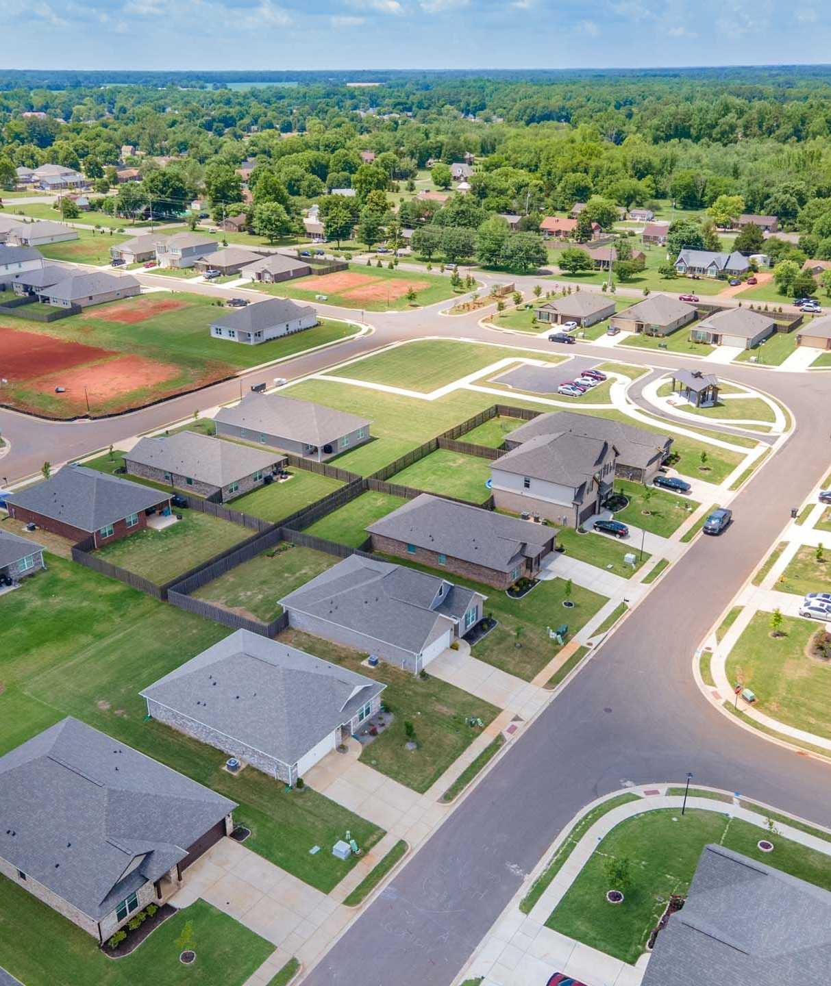 Aerial view of Clearview neighborhood in Hazel Green Alabama featuring new Davidson Homes, tree-lined streets, green lawns, and red clay tennis courts