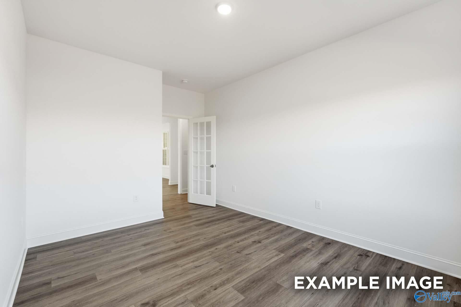 Bright home office or bedroom with French doors and wood-look flooring in The Valencia floor plan, Briercreek, Meridianville.