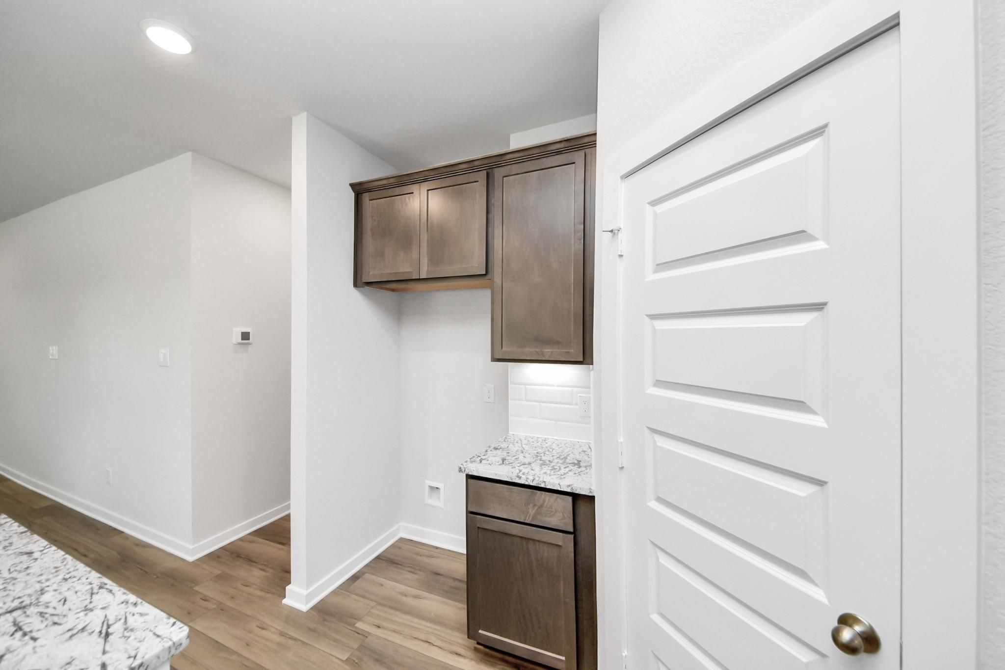Butler's pantry with granite countertops and dark wood cabinets in The Sabine E floor plan, Liberty Estates, Cleveland, TX.