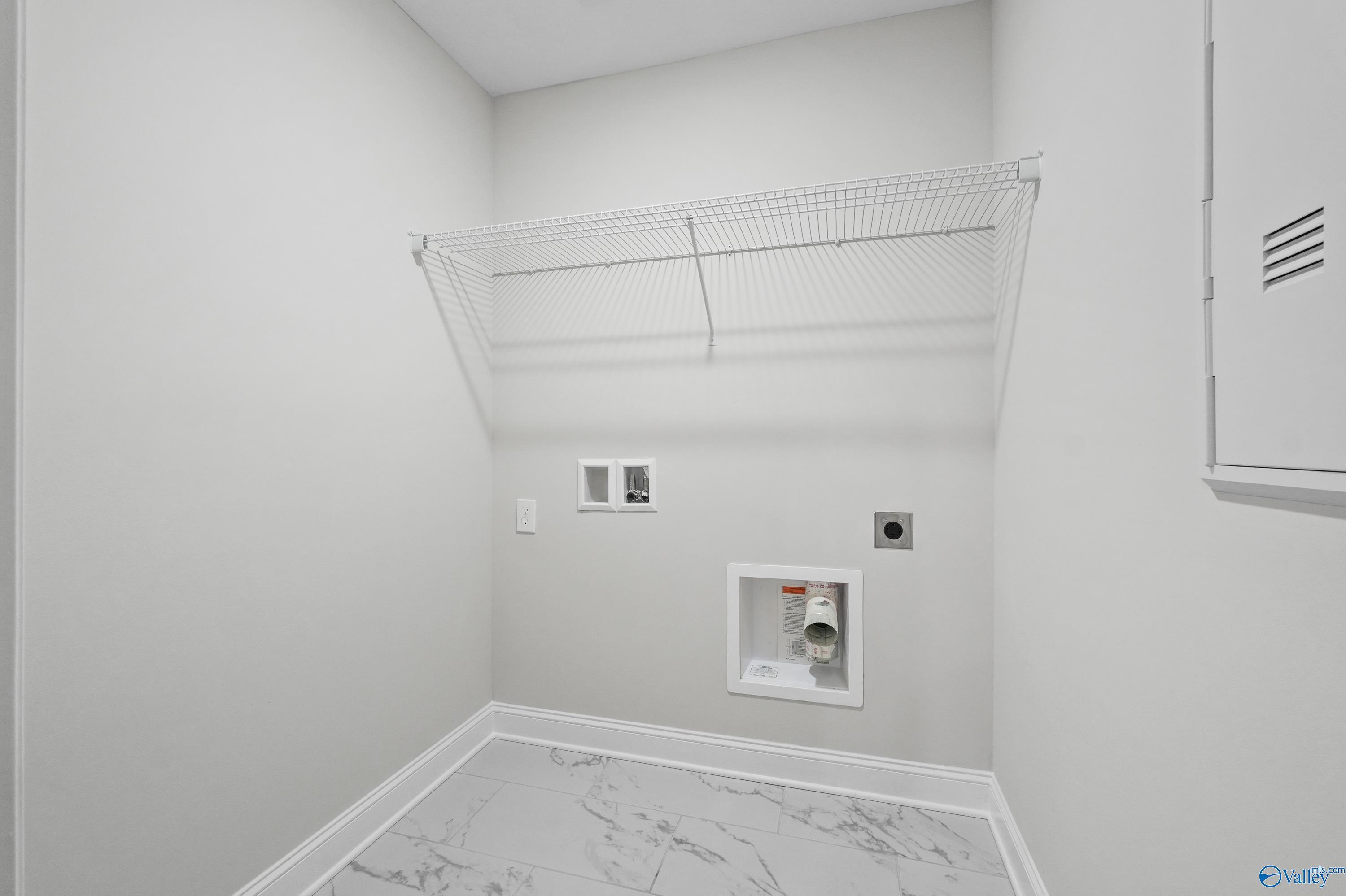 Modern laundry room featuring wire shelving, washer-dryer hookups, utility sink in Davidson Homes The Camden, Huntsville AL