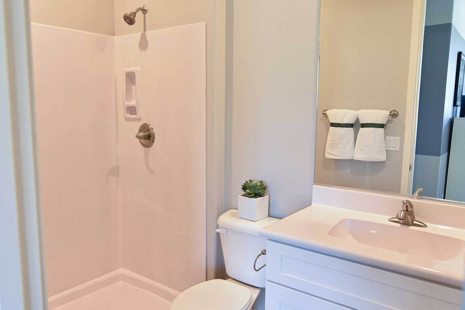 Master bathroom in The Summit B by Evermore Homes featuring white tiled shower, modern vanity sink, and neutral Prescott Valley design