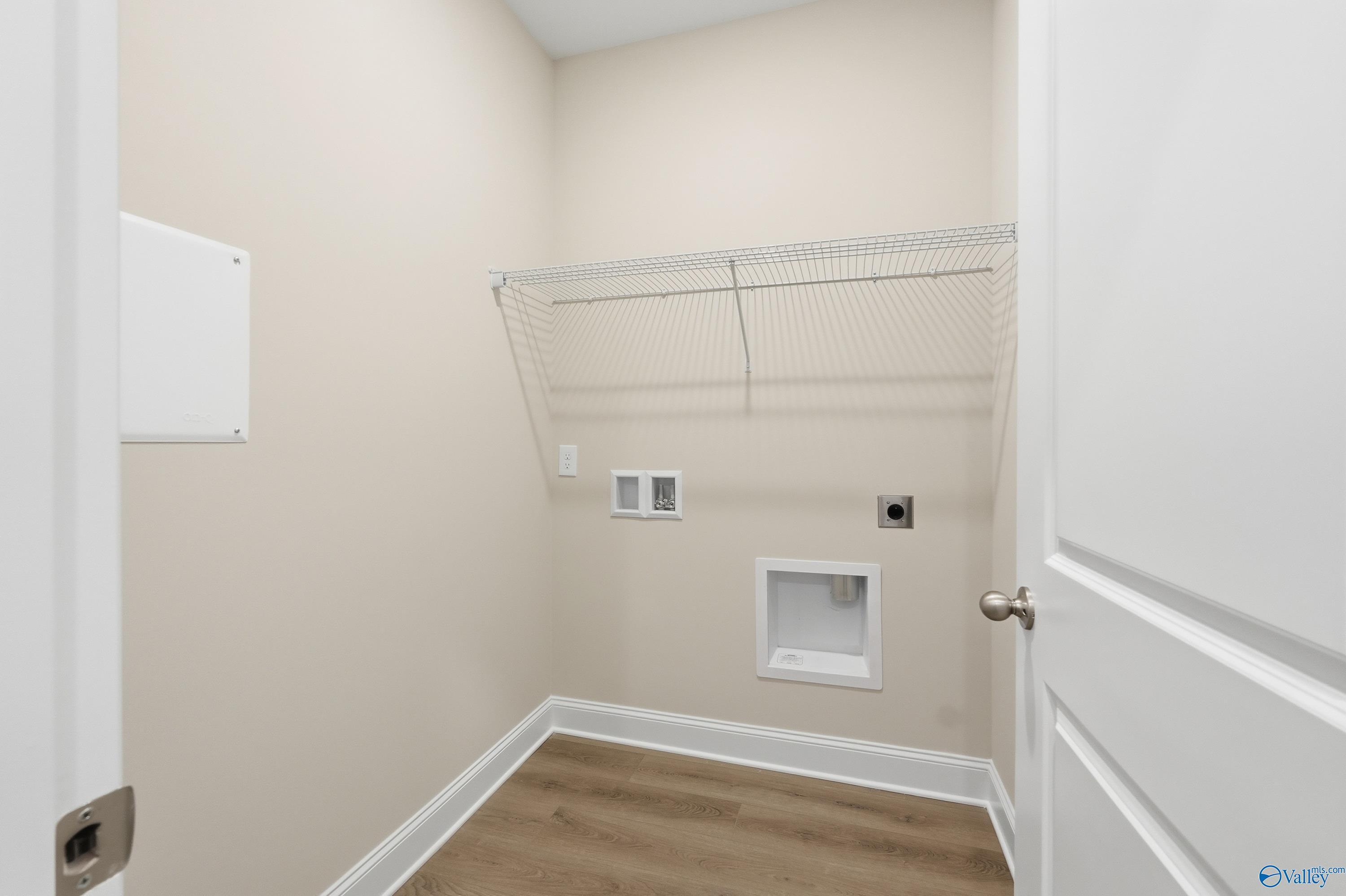 Spacious laundry room with wire shelving, utility sink, and outlets in The Asheville floor plan by Davidson Homes, Toney, Alabama