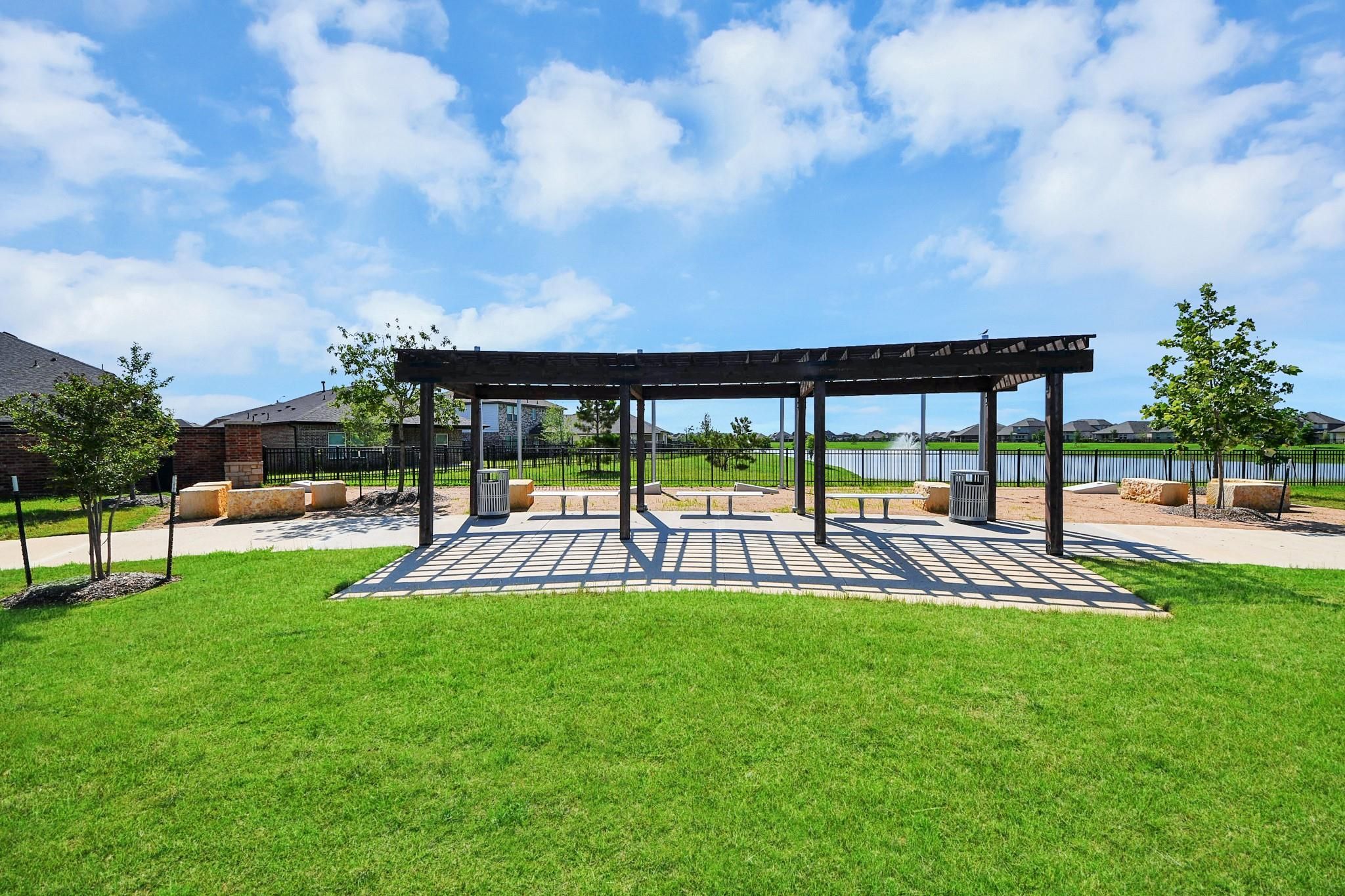 Outdoor pergola with benches in the community park at Sunterra in Katy, Texas, near Davidson Homes' Luna J floor plan.