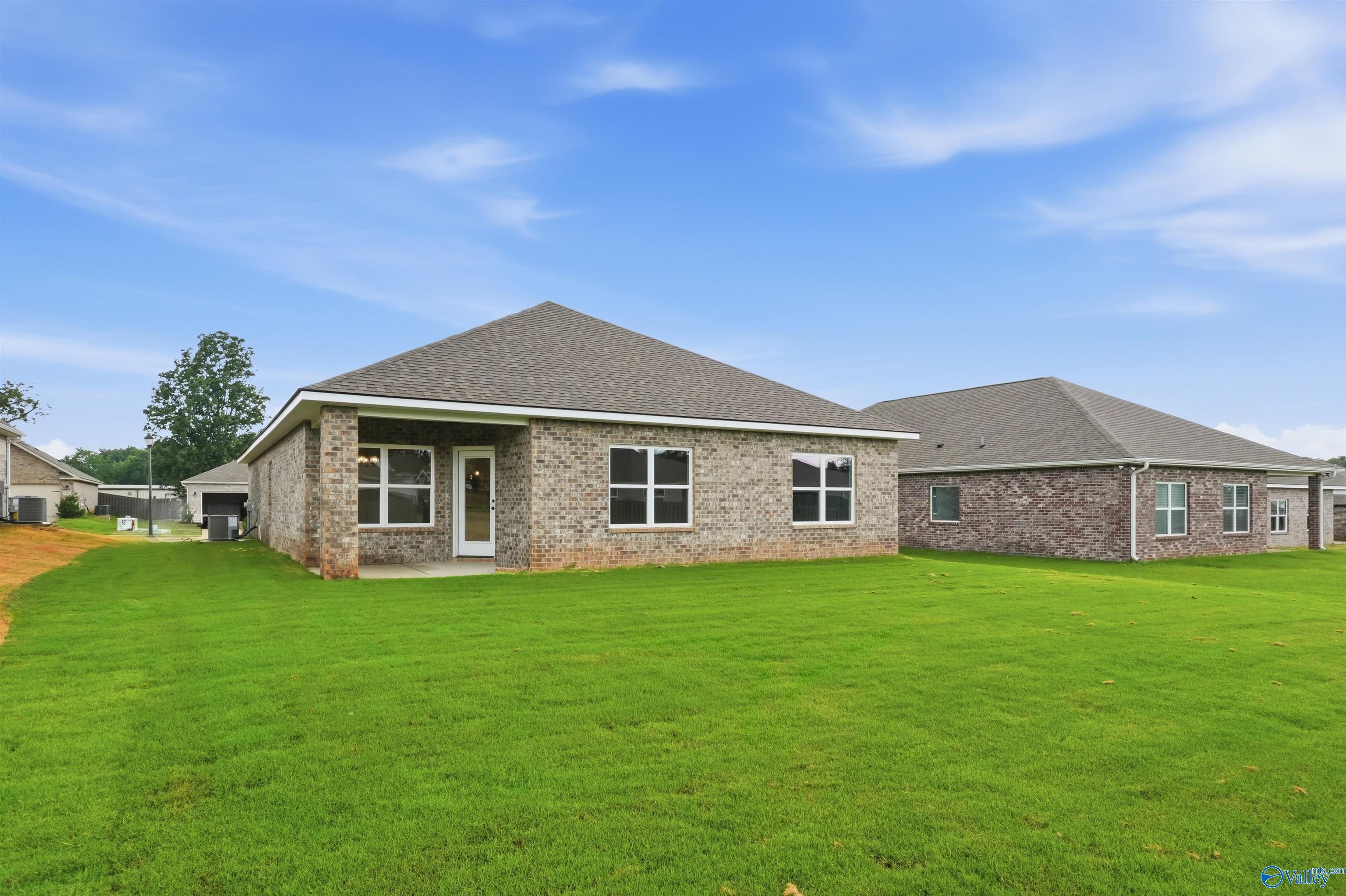 Back exterior view of The Daphne C floor plan by Davidson Homes with a spacious backyard in Flint Meadows, New Market, AL.