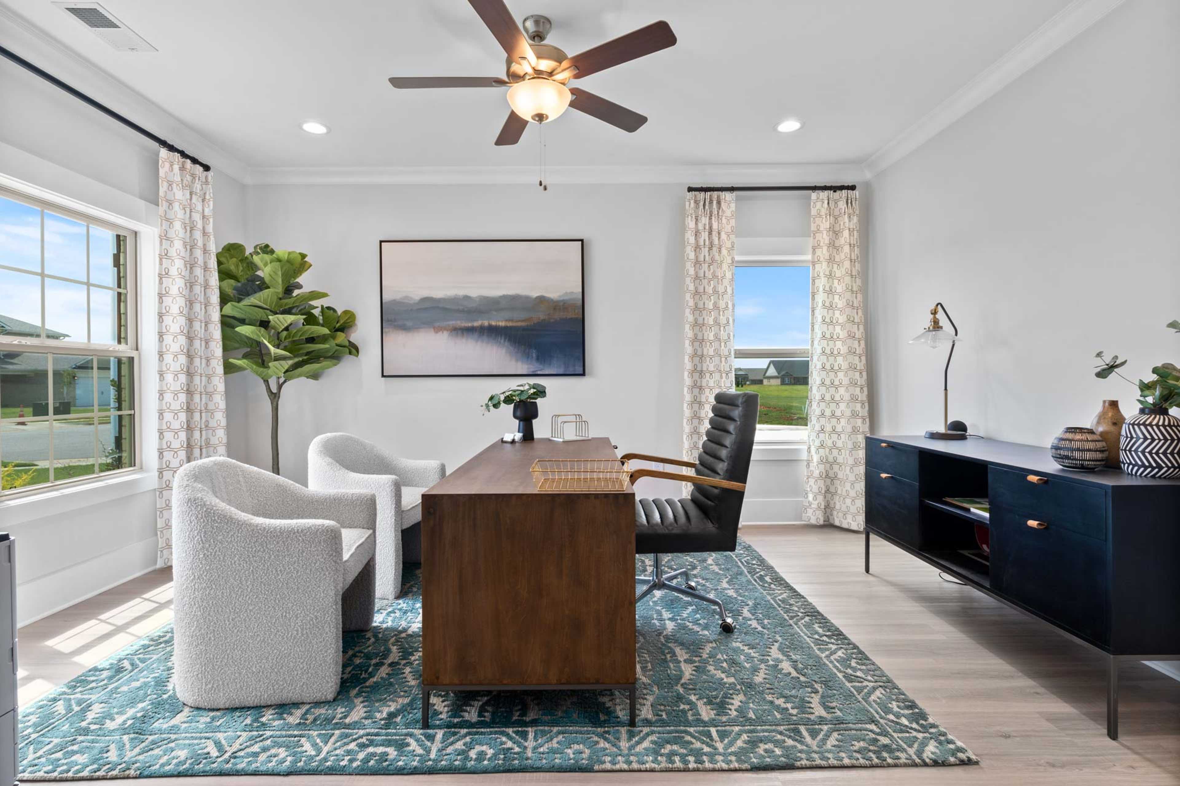 Spacious home office at Walker's Hill in Meridianville Alabama featuring wooden desk, leather chair, large windows and plants