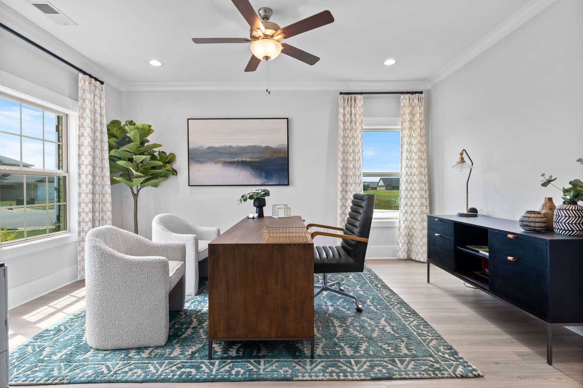 Spacious home office at Walker's Hill in Meridianville Alabama featuring wooden desk, leather chair, large windows and plants