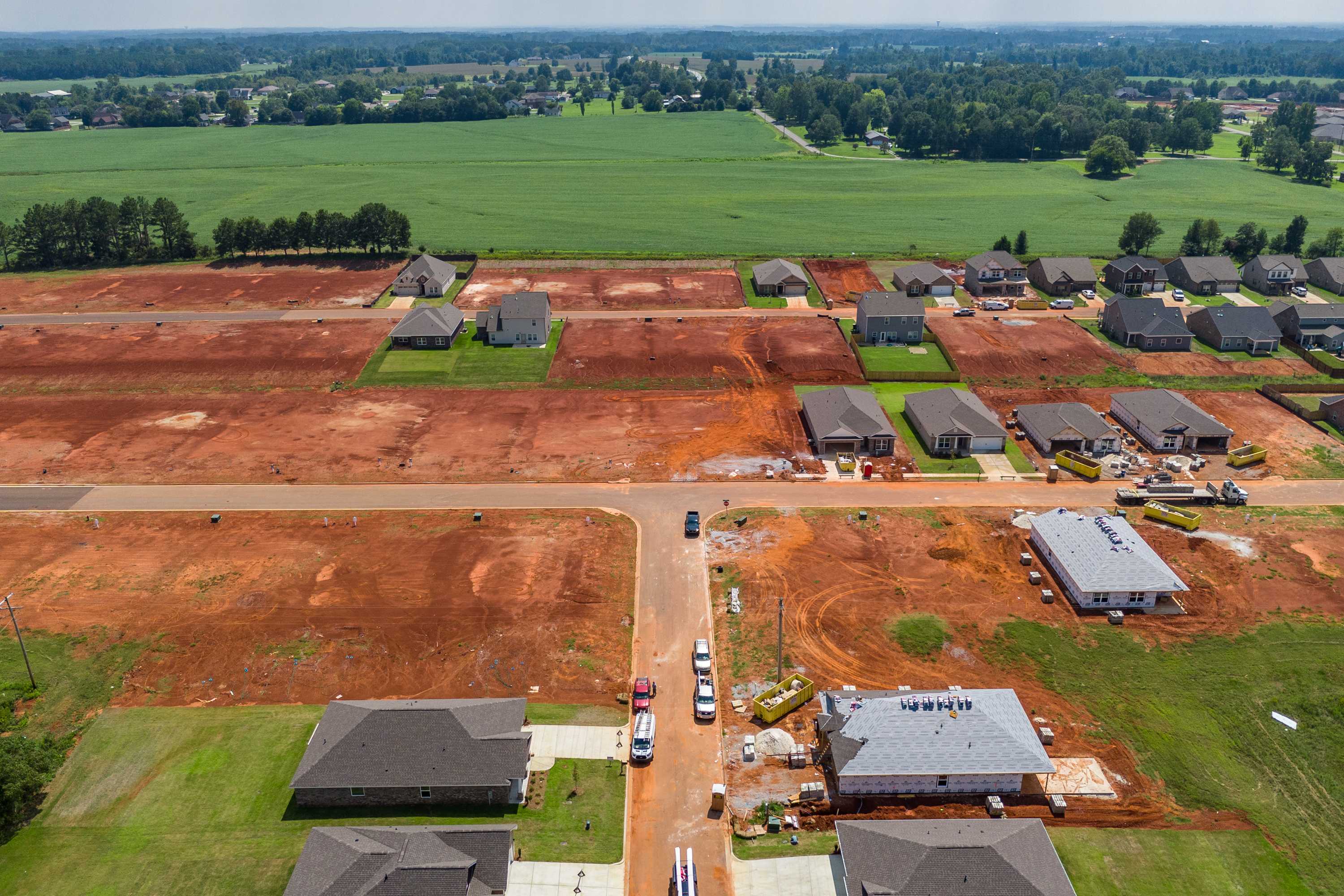 Aerial view of Ricketts Farm new homes construction in Athens Alabama by Davidson Homes with red clay lots and surrounding farmland