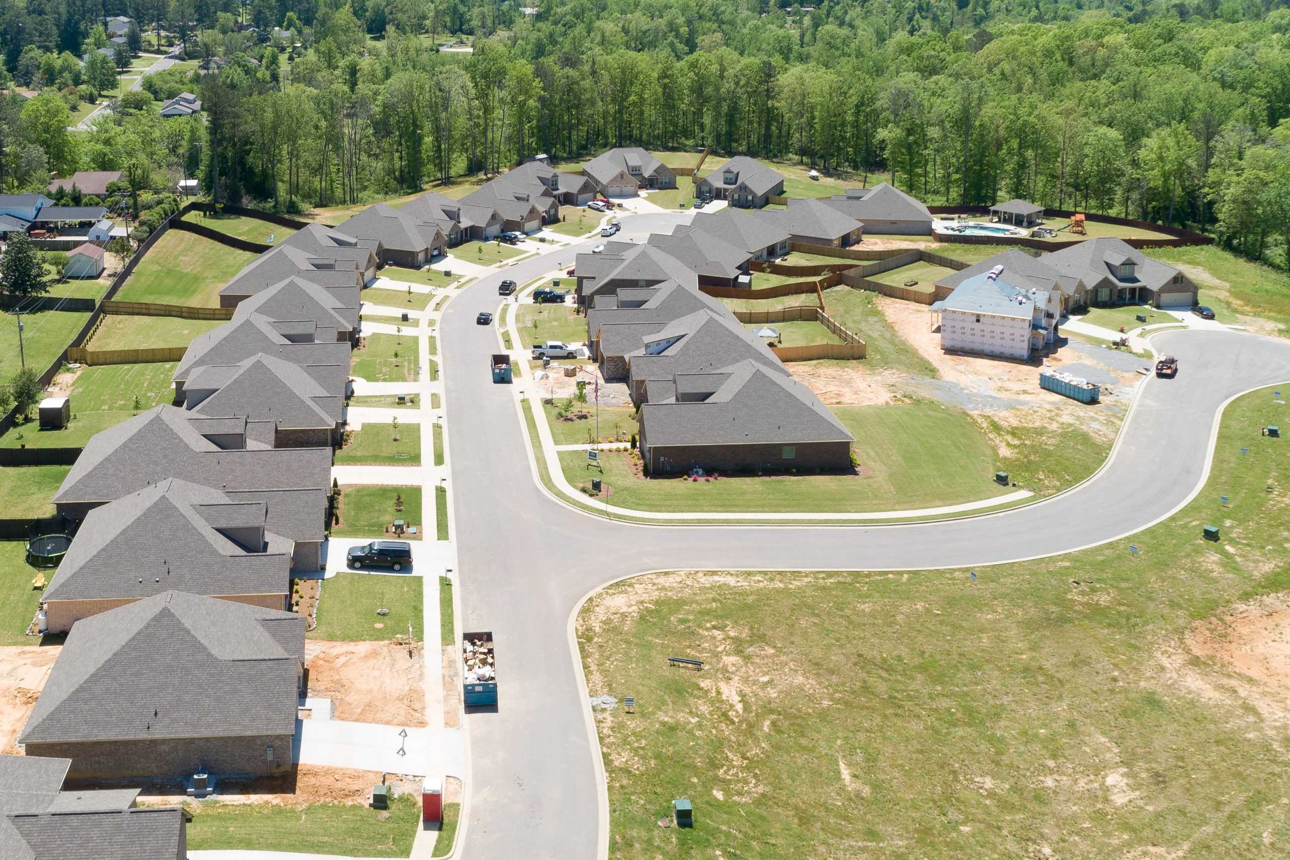 Aerial view of Stone Creek Phase II neighborhood in Cullman Alabama featuring new gray-roofed homes under construction with winding streets and green lawns