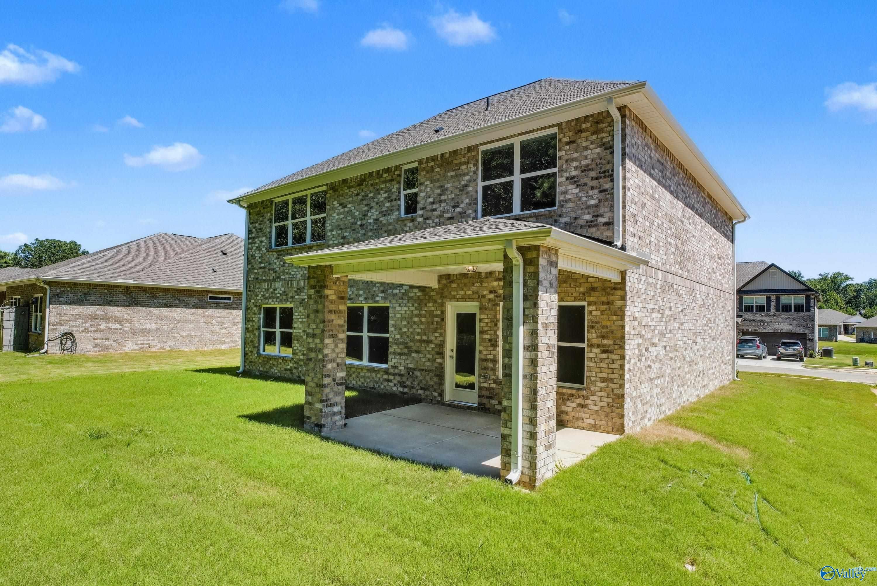 Two-story brick home with covered front porch, attached garage, and lush green lawn in The Highlands, Arab, Alabama - Davidson Homes The Shelby A