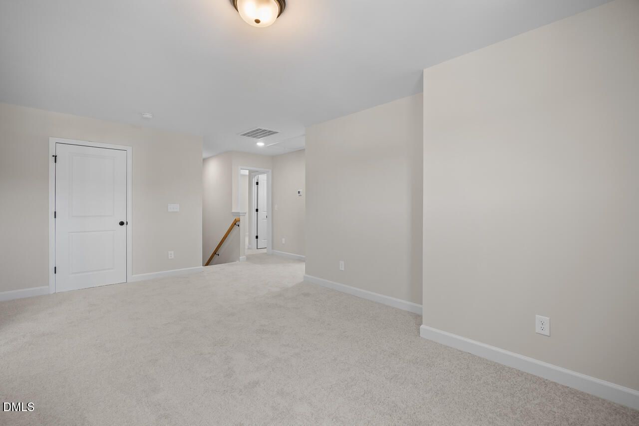 Spacious carpeted bedroom with neutral walls and ceiling light in Davidson Homes The Ashport M, Wendell Ridge, North Carolina