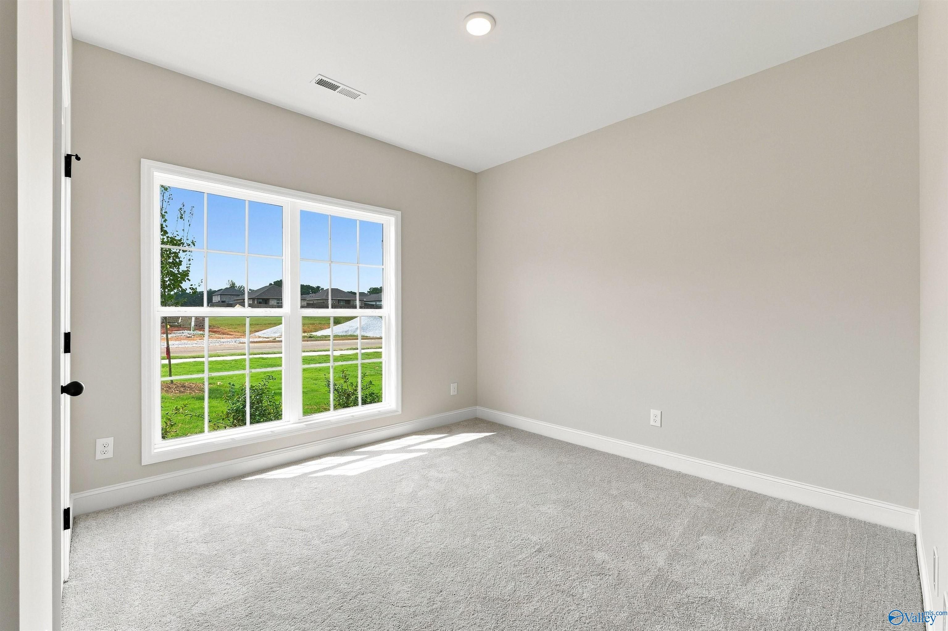 Bright bedroom with large window and carpet in Davidson Homes Franklin C plan at The Meadows, Athens, Alabama