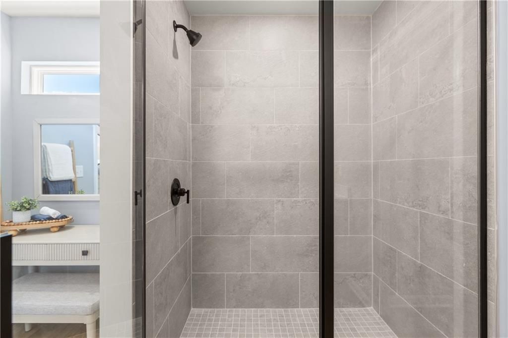 Modern walk-in shower with gray subway tiles, black frameless glass doors, and rainfall showerhead in Davidson Homes The Burton C, Canton, GA