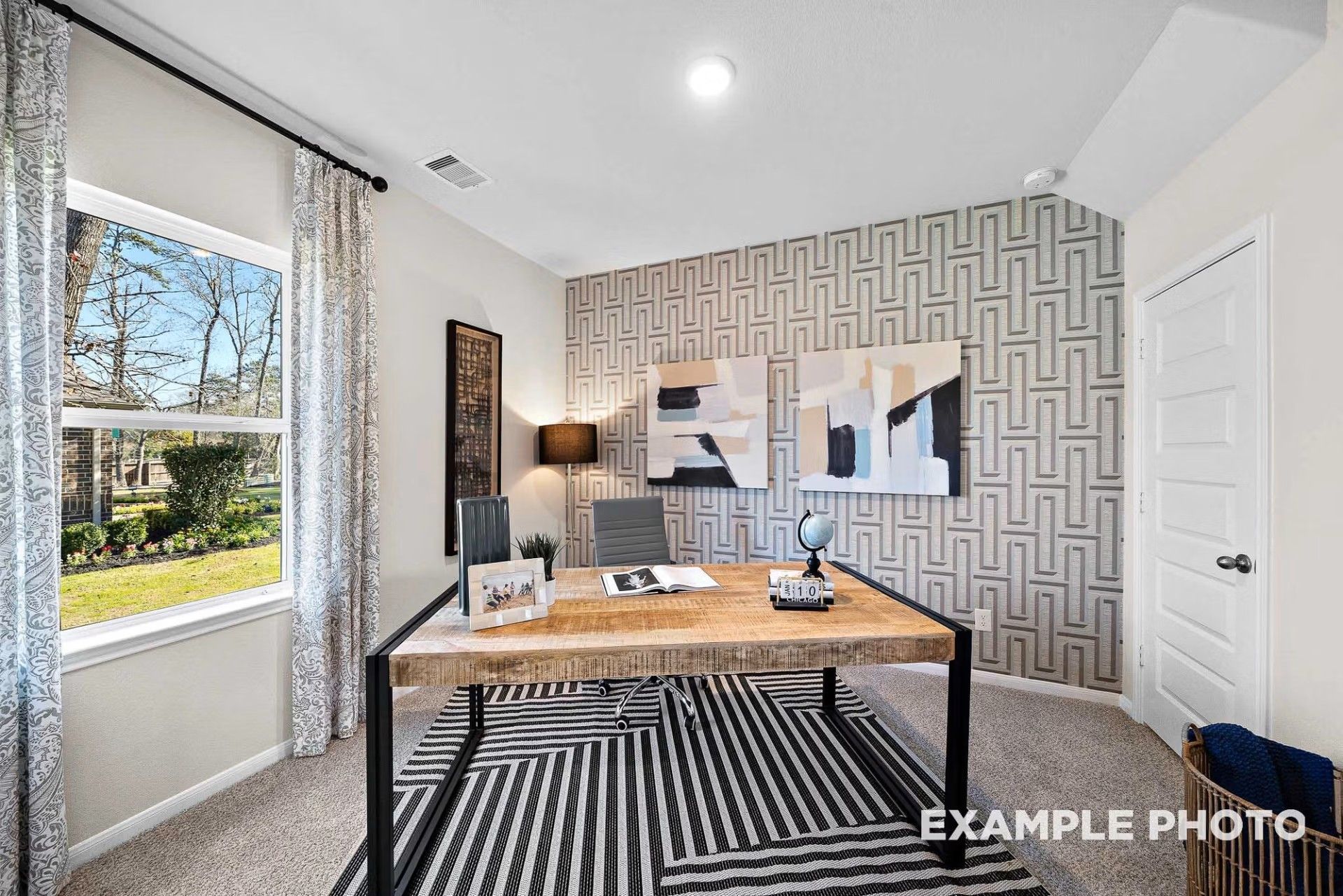 Modern home office with geometric wallpaper and rustic wooden desk in The San Marcos E floor plan by Davidson Homes.