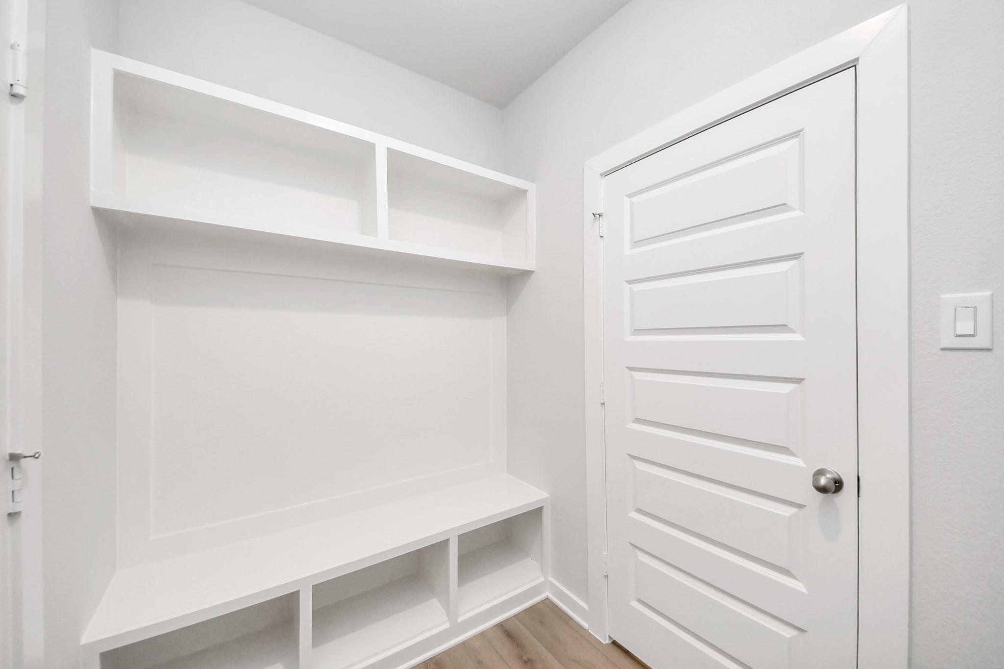 Built-in mudroom bench with storage shelving in The Frio F floor plan at Liberty Estates, Cleveland, Texas.