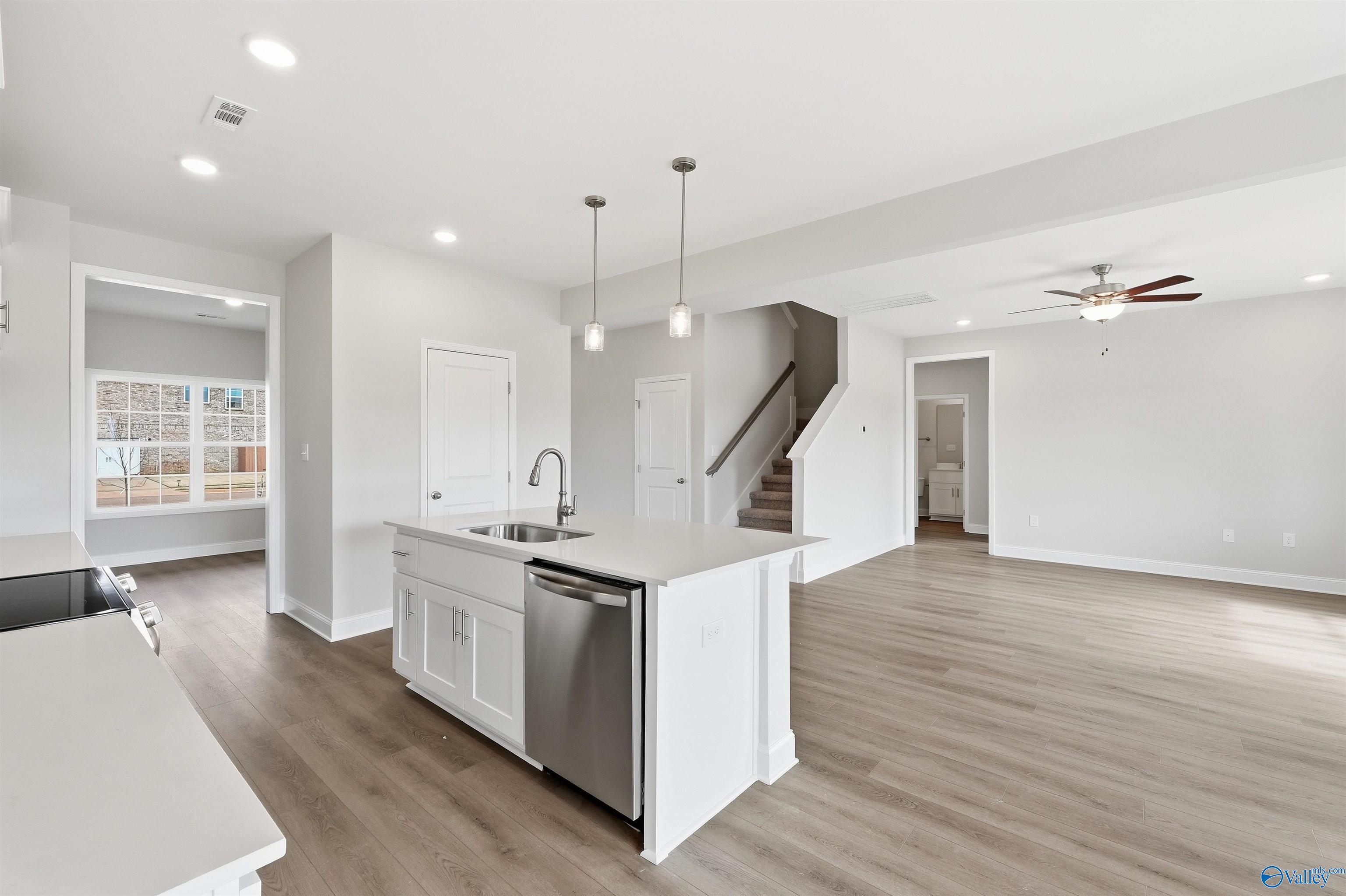 Open-concept kitchen with white island and stainless appliances in The Shelby D floor plan, Evergreen Mill, Madison, AL.