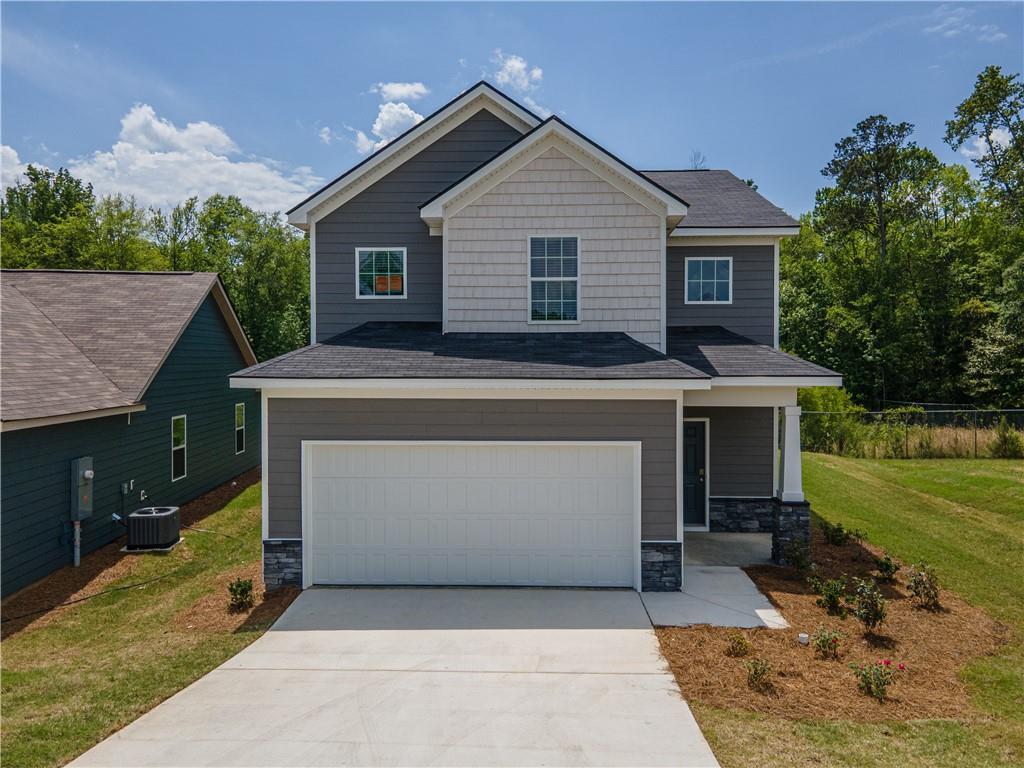 Modern two-story gray home with white 2-car garage, concrete driveway, and landscaped yard in Summer Vineyard, Phenix City, Alabama - Davidson Homes The Bartlett