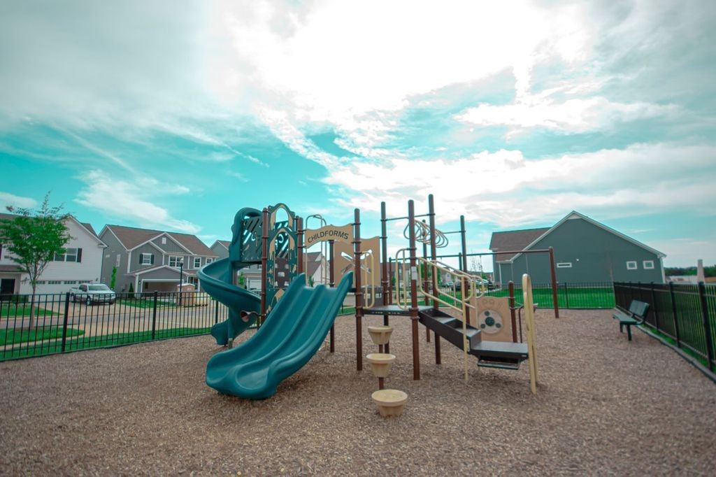 Vibrant playground with green slides, climbing structures, and mulch play area in Shelton Square, Murfreesboro, Tennessee, Davidson Homes community