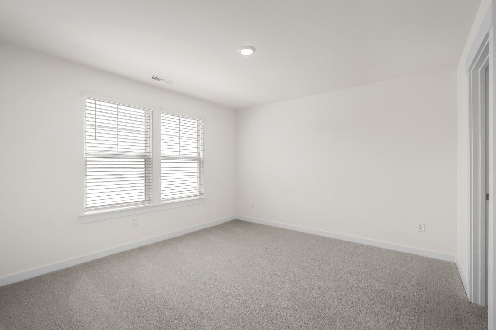 Bright, spacious carpeted bedroom in The Willow floor plan at Woods Crossing, Gallatin, Tennessee.