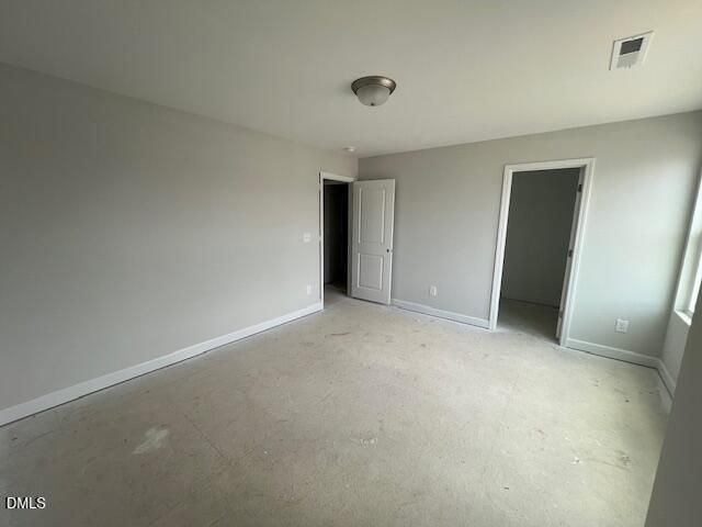 Empty bedroom with light gray walls, white trim, double closets, and window in 4-bedroom Adalynn B home, Lillington, NC