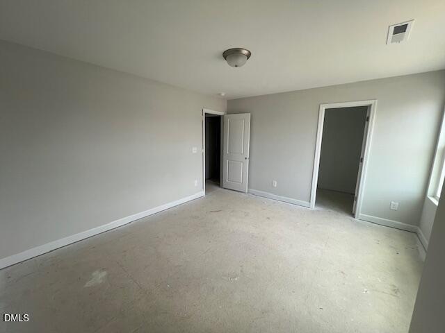 Empty bedroom with light gray walls, white trim, double closets, and window in 4-bedroom Adalynn B home, Lillington, NC