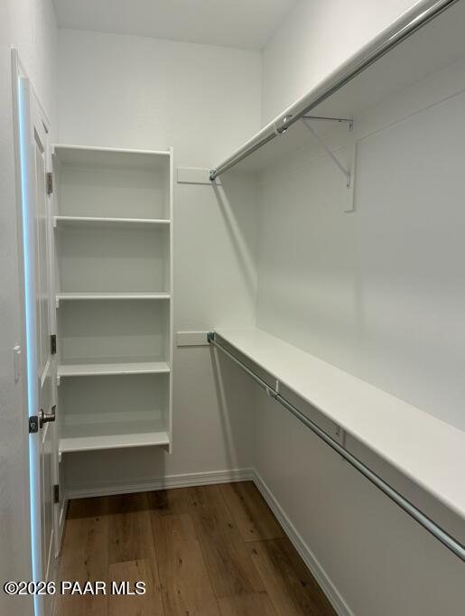 Walk-in closet with white shelving and wood-style flooring in The Coronado A floor plan at South Ranch, Prescott, Arizona.