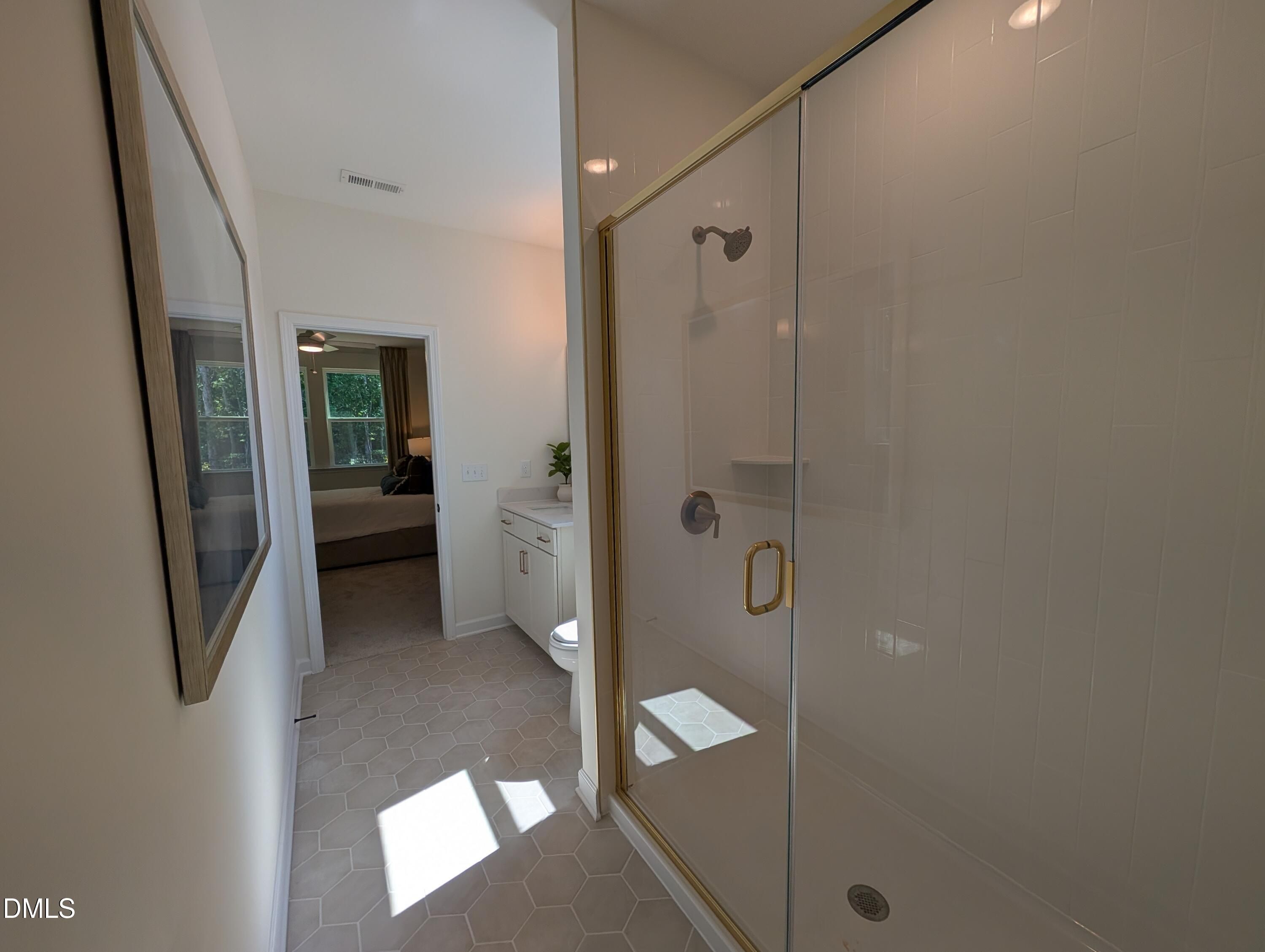Modern bathroom with glass-enclosed shower and hexagon tile flooring in The Aspen B floor plan, Wendell Ridge, NC.