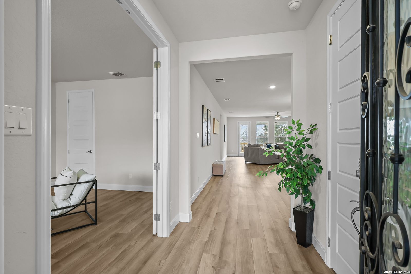 Bright entryway with wood-look flooring leading to open-concept living area in Davidson Homes Lanier H floor plan, Ladera.