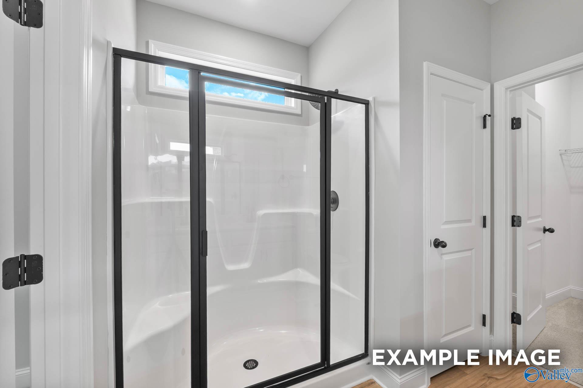 Modern walk-in shower with black frame in The Asheville C floor plan at Walker's Hill in Meridianville, Alabama.