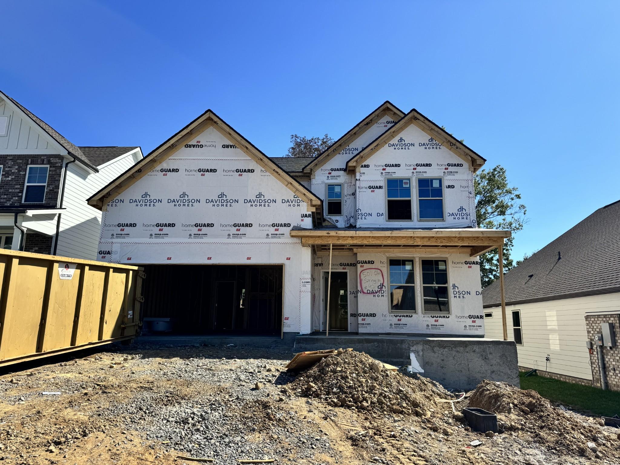 Two-story Davidson Homes construction under blue sky in Woods Crossing, Gallatin, Tennessee — The Henry B 5-bedroom new home plan