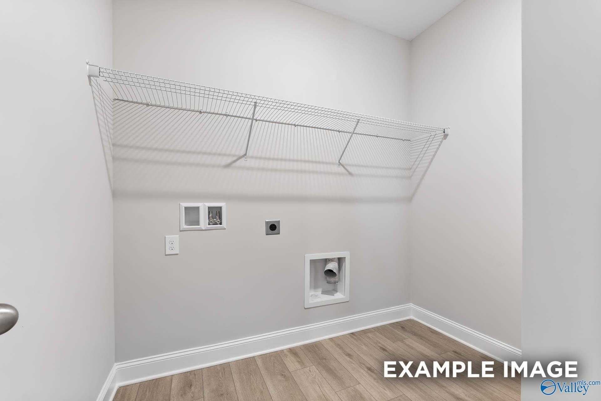 Spacious laundry room with wire shelving and washer-dryer hookups in Davidson Homes The Daphne C, New Market, Alabama