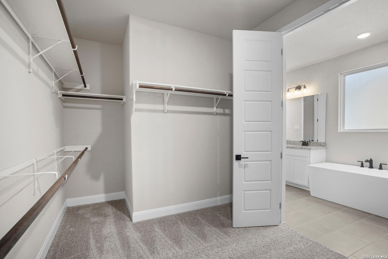 Walk-in closet with built-in shelving leading to a master bathroom in The Jennings G floor plan by Davidson Homes.