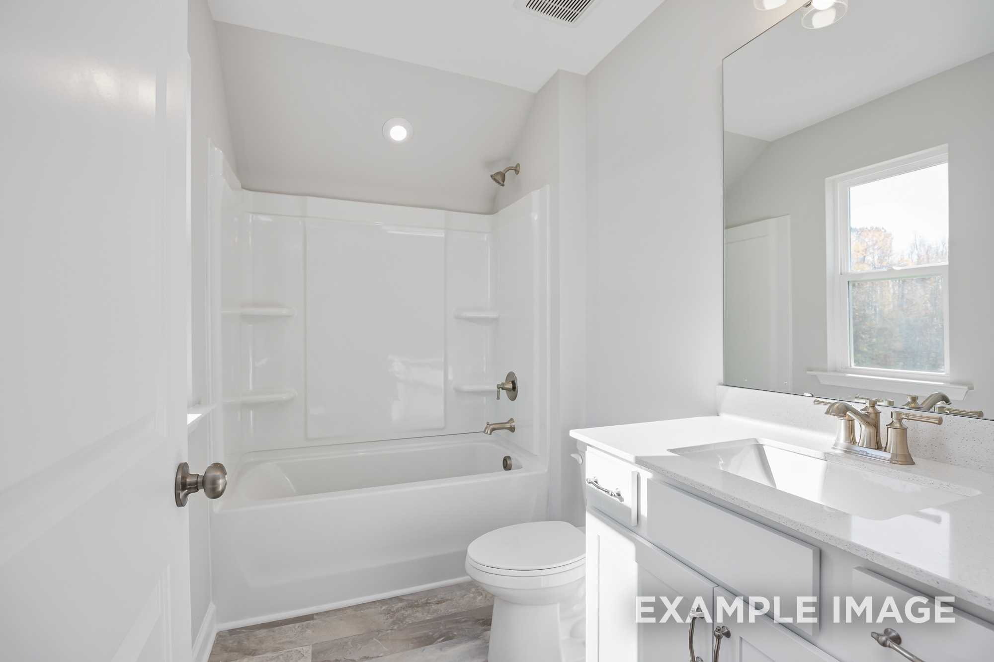 Spacious master bathroom in The Cypress D II featuring white tub, walk-in shower, double vanity, and large window
