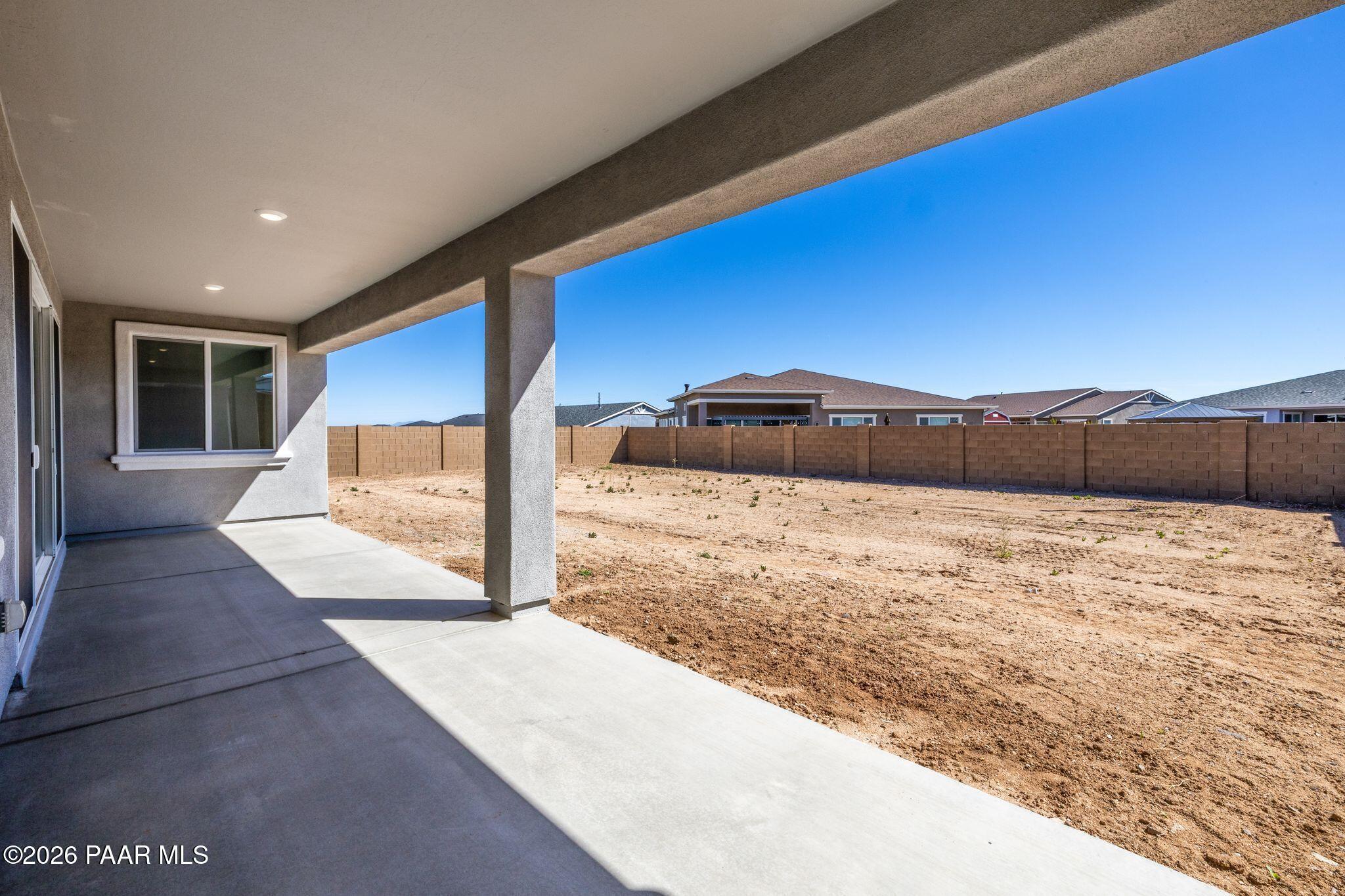 Covered back patio with sliding glass doors and stucco exterior in Davidson Homes The Monarch A, Westwood, Prescott, Arizona