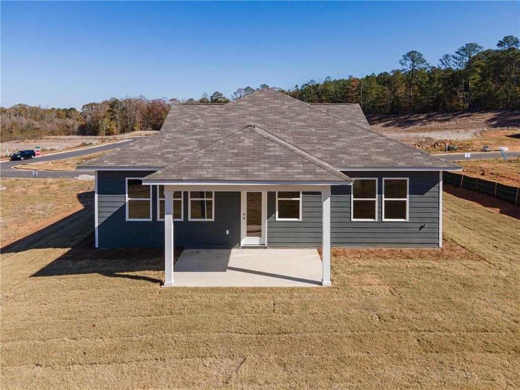 Rear view of gray single-story The Luna B home by Davidson Homes, covered patio, large windows, wooded lot in Anderson Lakes, Opelika, Alabama