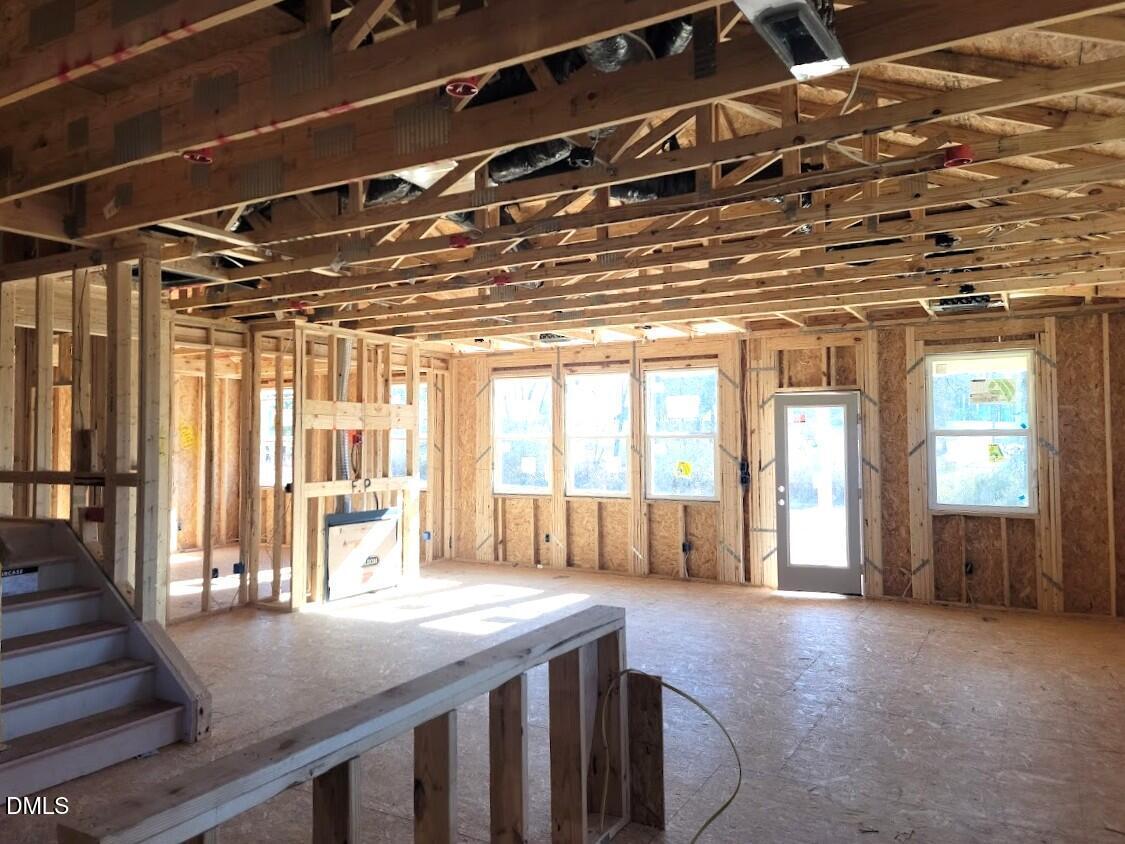 Spacious framed living area with exposed beams, large windows, and staircase in under-construction 5-bedroom Davidson Homes Ashport G, Angier, NC